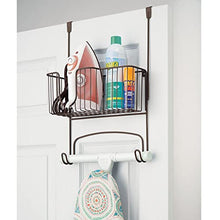 Load image into Gallery viewer, mDesign Metal Over Door Ironing Board Holder with Large Storage Basket - Holds Iron, Board, Spray Bottles, Starch, Fabric Refresher - for Laundry, Utility Room, Garage - Bronze
